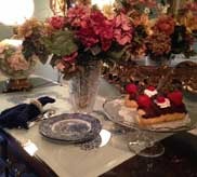 Elegant table setting with floral arrangement, blue china and desserts