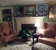 Cozy sitting room with fireplace, wingback chairs and blue china collection